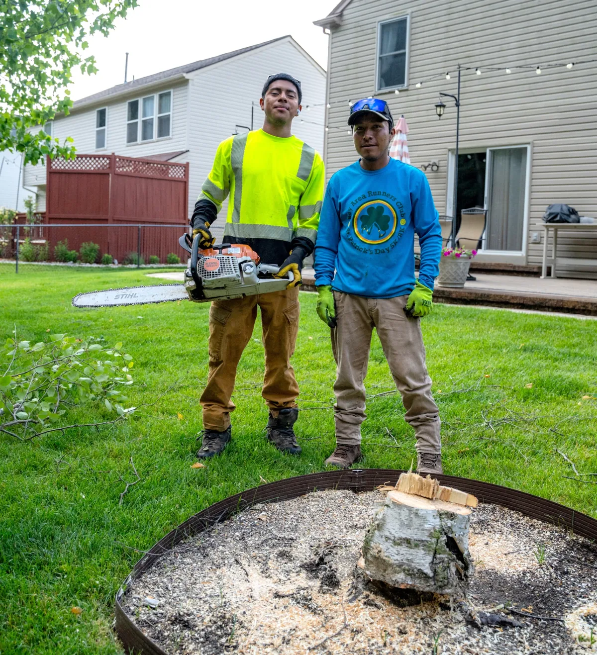 Nate's Outdoor Services crew with chainsaw after removing a tree